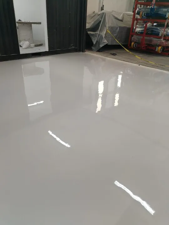 Piso autonivelante blanco con acabado de alto brillo.