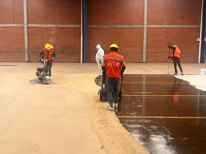 Equipo de Pinturas Industriales SM preparando el concreto y aplicando primario en una nave industrial.
