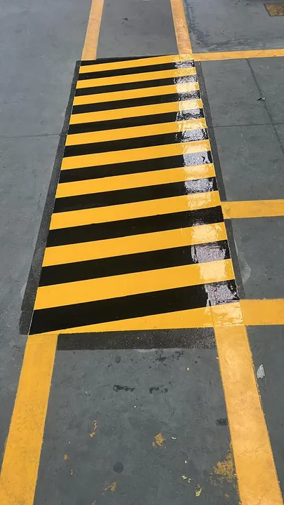 Franjas de seguridad amarillo con negro pintadas sobre piso de concreto industrial.